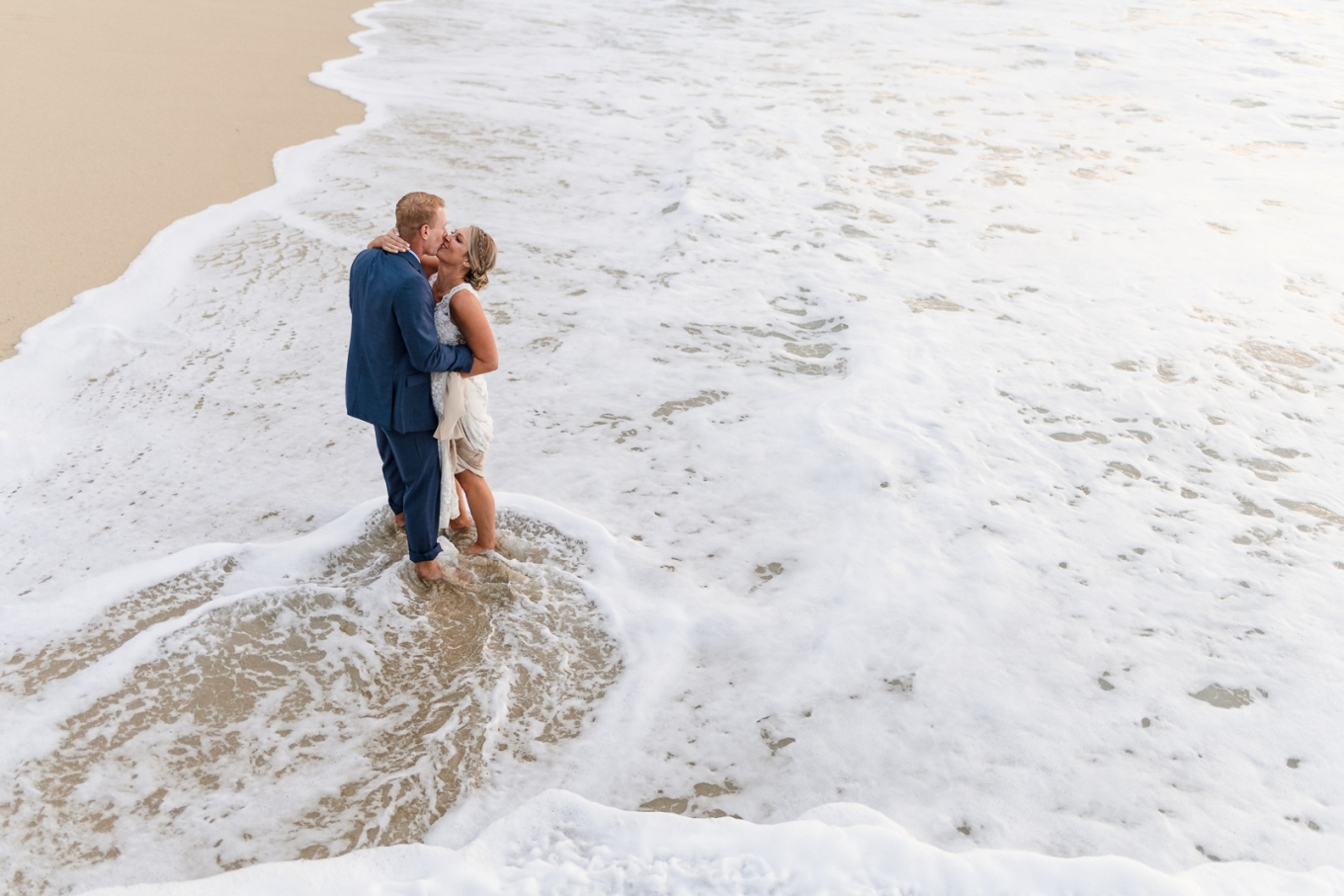 couple kissing in the surf - elope on the beach