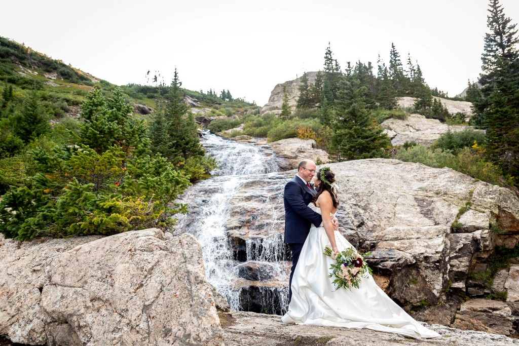 Bride and groom at waterfall - Rocky Mountain destination wedding