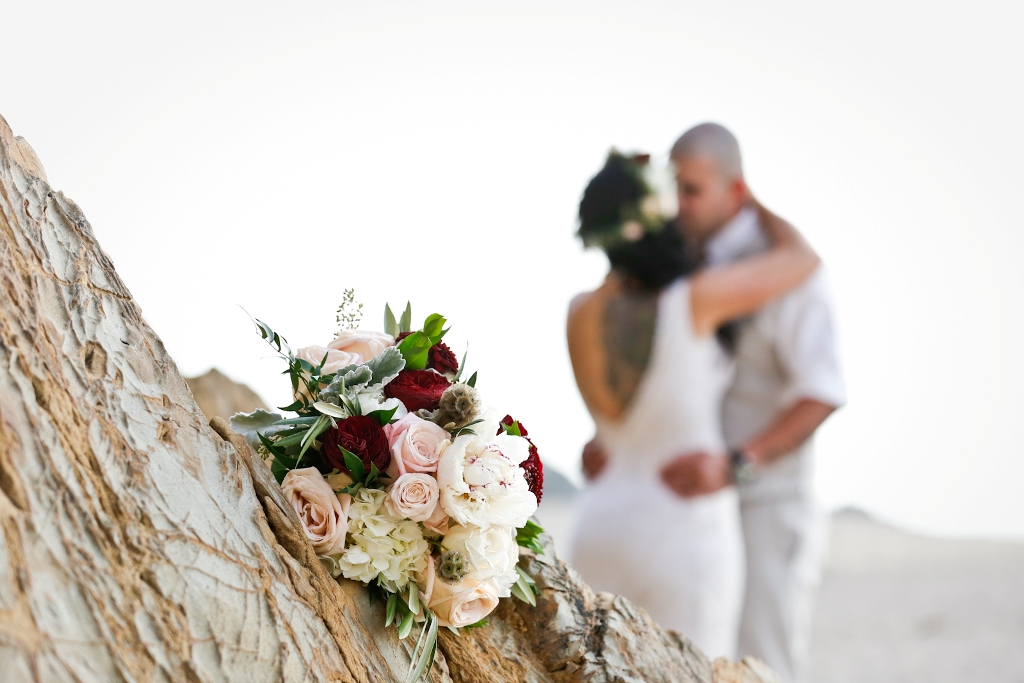 Bridal bouquet with couple kissing in the background