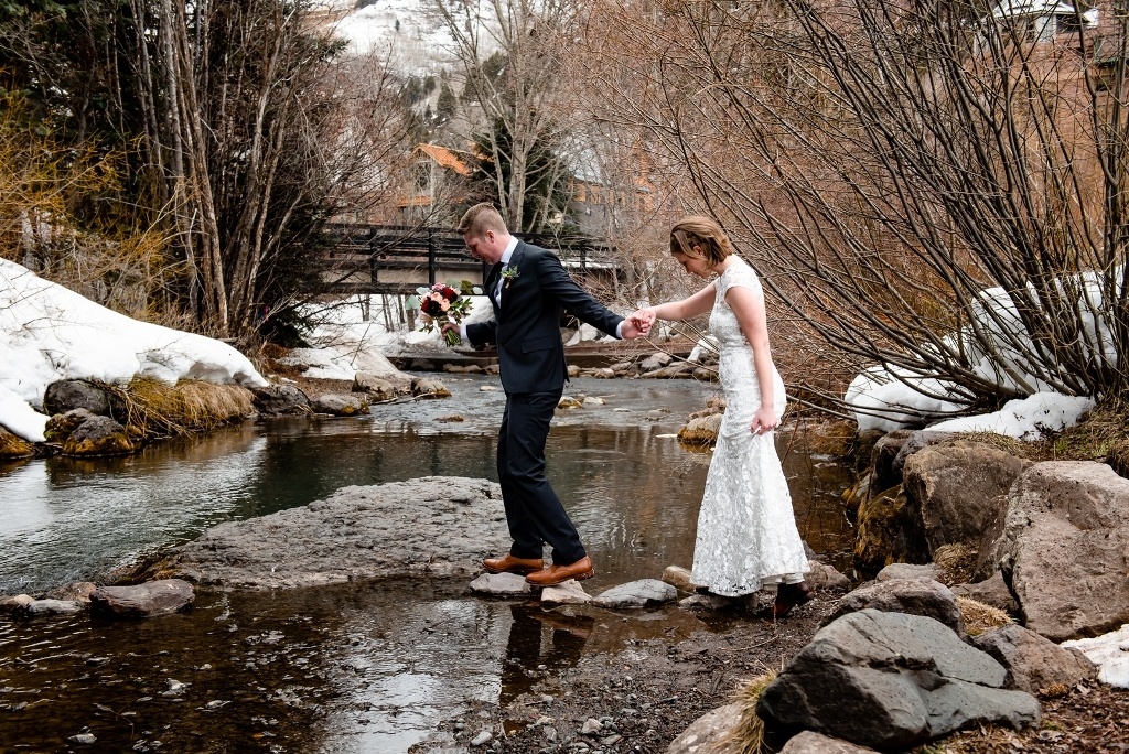 crossing the creek for their Telluride wedding photo shoot