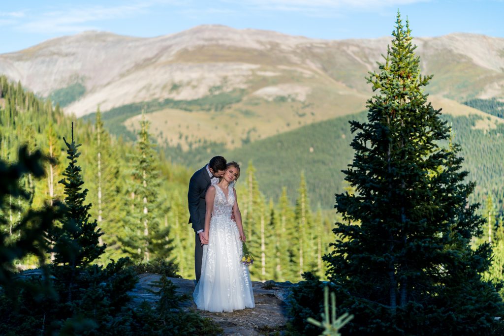couple kissing on a mountaintop in Colorado