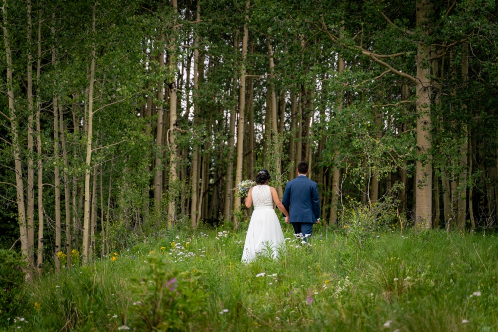 couple walking hand in hand into the woods