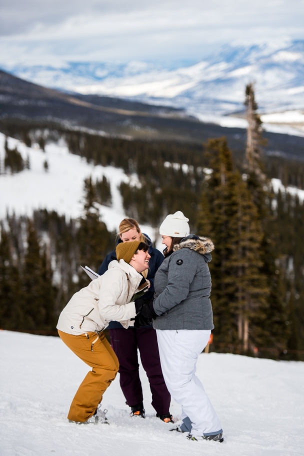 Laughing bride eloping on a snow-covered mountain