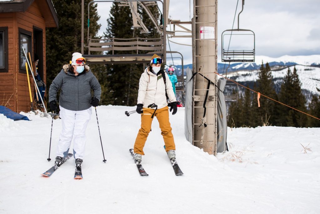 two brides wearing masks for their elopement on the slopes during the pandemic