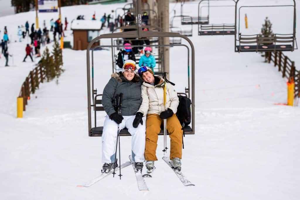 Mollie and Margot riding the lift to get married on the ski slopes of Breckenridge