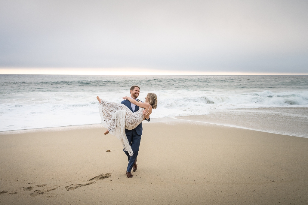 Couple playin on the beach in California after eloping