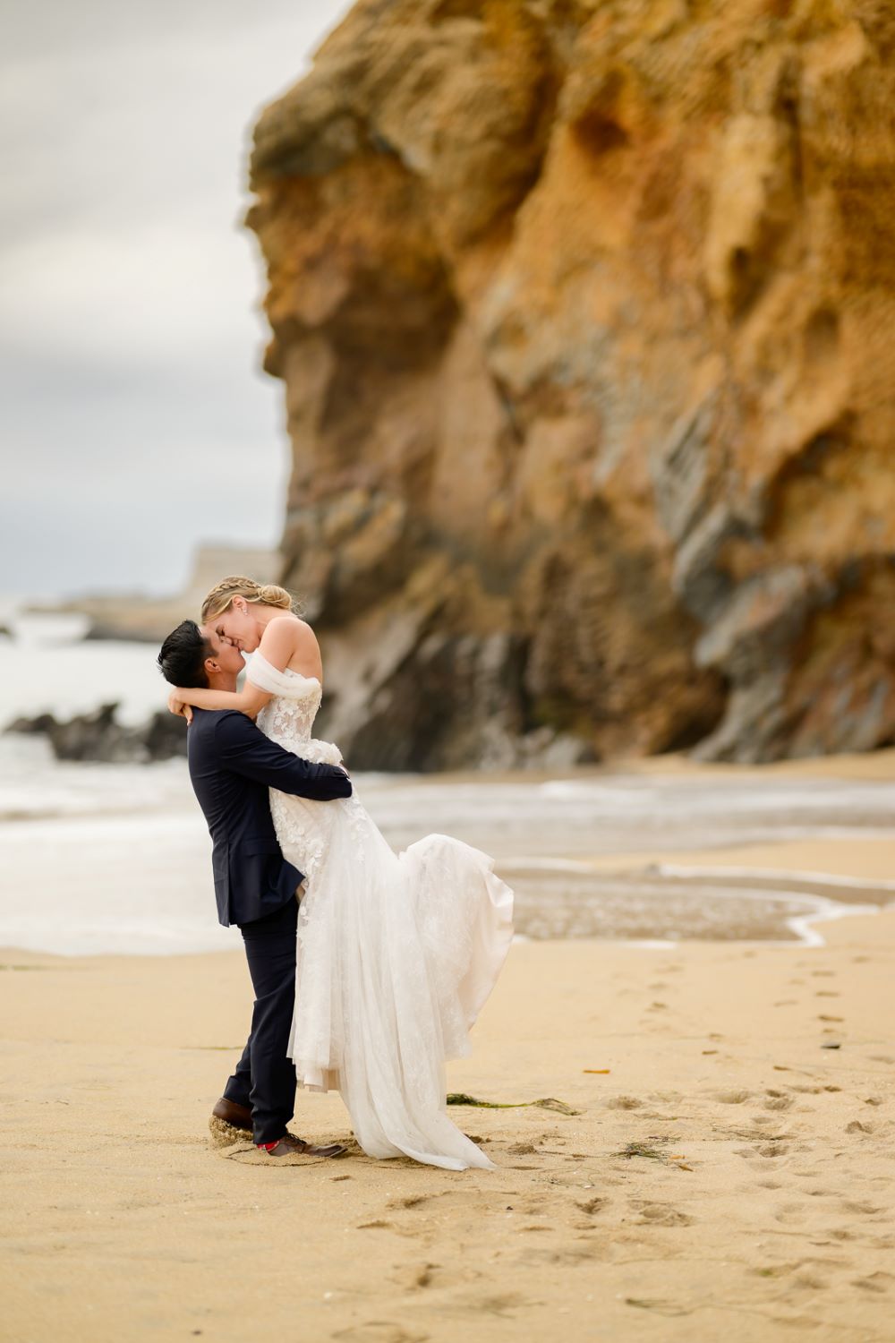 A couple on a beach after purchasing an elopement package in California