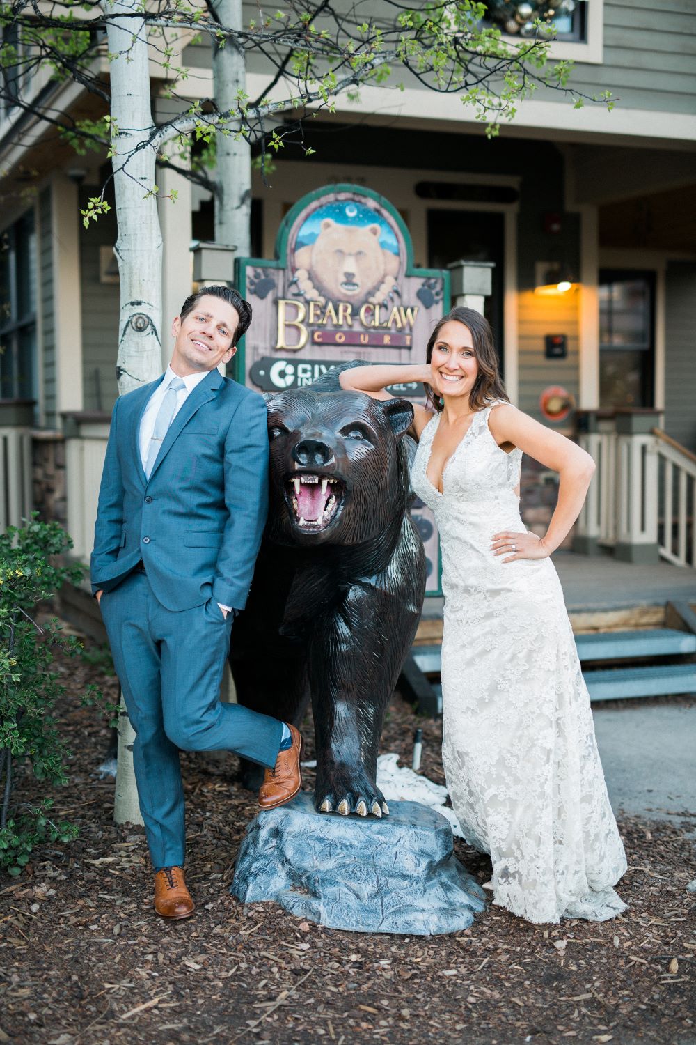 Newlyweds with sculpture of bear in Breckenridge