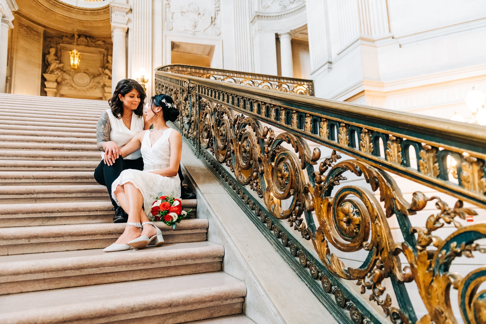 San Francisco City Hall eloping same-sex couple sitting on the grand staircase